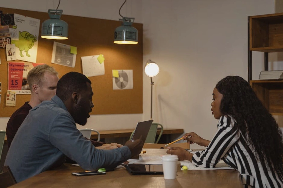 Tým spolupracující nad projektem u stolu s poznámkami a diagramy